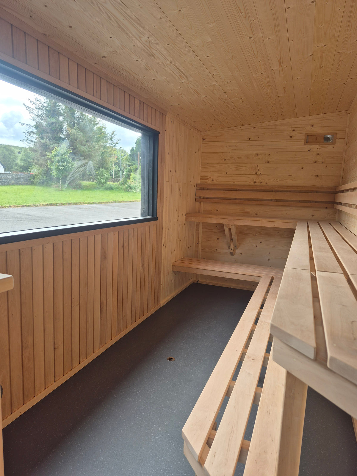Atlantic mobile sauna interior with panoramic window and spacious two-tier wraparound seating