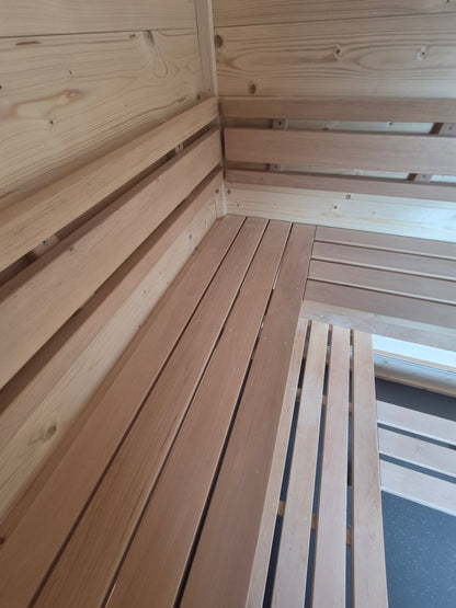 Close-up of handcrafted timber sauna benches and backrests inside the Atlantic mobile sauna